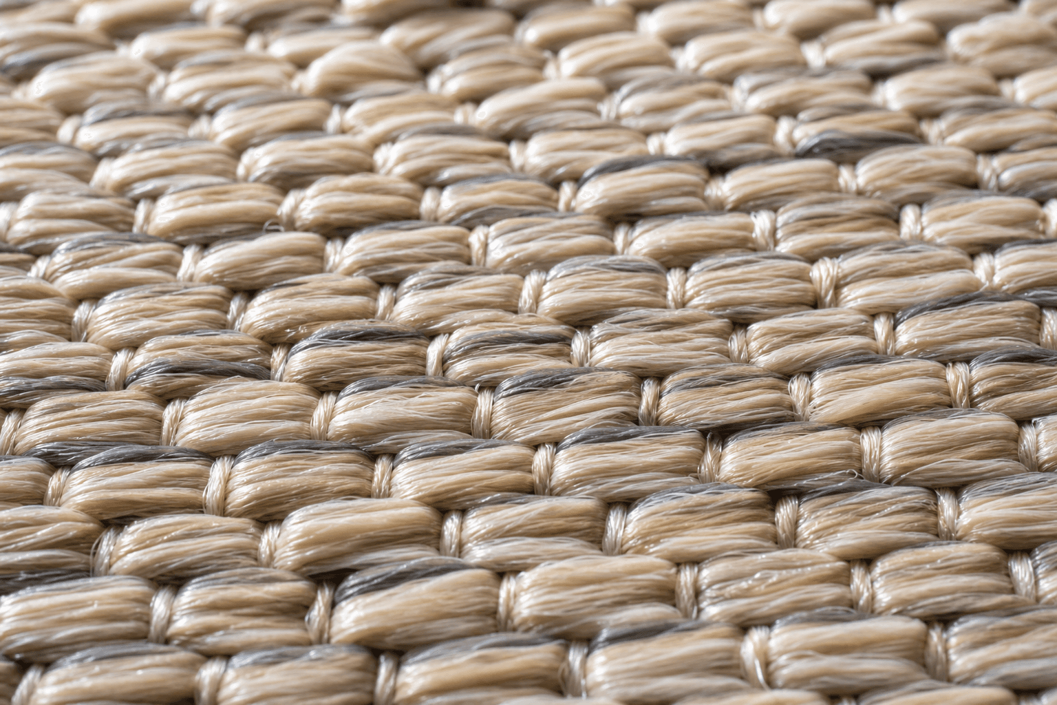 Närbild på flatvävd polypropenmatta med tät fiberstruktur i naturton